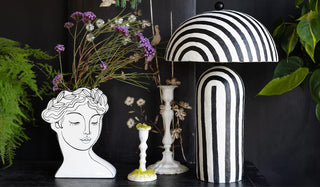 The Peaceful Monochrome Lady Vase and Black & White Stripe Paper Mache Table Lamp styled together on a sideboard with greenery and candlestick holders.