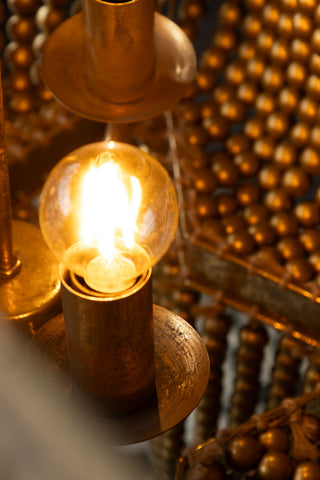 Detail shot of a lit bulb inside the Gold Star Shaped Beaded Statement Chandelier Light.