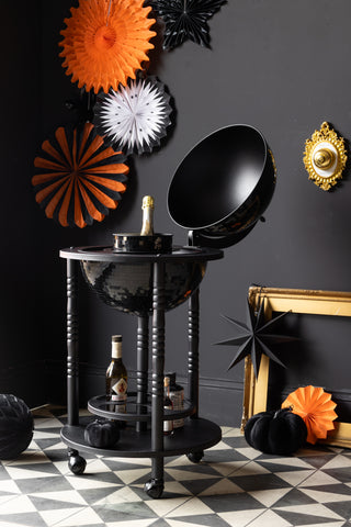 Set Of 7 Black & Orange Paper Decorations against a dark wall with a black disco ball bar cart