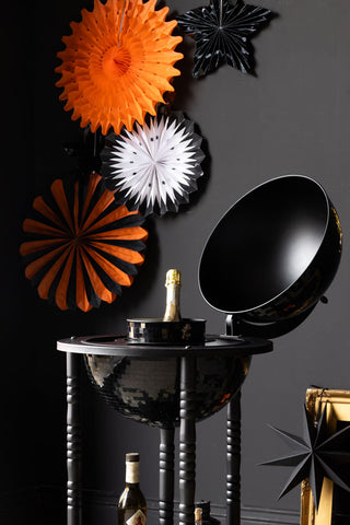 Set Of 7 Black & Orange Paper Decorations against a dark wall with a black disco ball bar cart close up