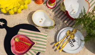 An outdoor tablescape styled with various tableware including colourful fruity items.