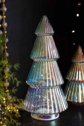 The Large Glass Christmas Tree With LED Lights styled with a smaller version, greenery, Christmas decorations and fairy lights.