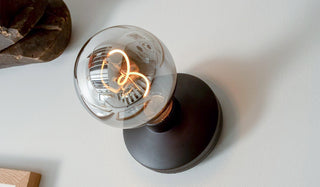 The Humble - Wall Light Cable-Free Mood Lighting in Black, displayed on a white wall.