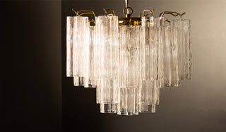 A beautiful glass chandelier displayed in front of a dark background.