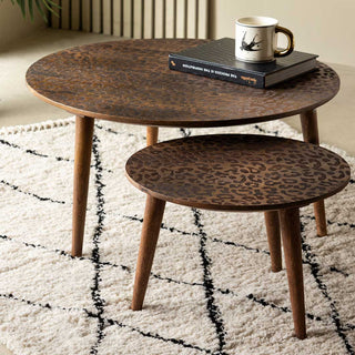 The Natural Leopard Love Nest Of Coffee Tables with a mug and book on, displayed on a patterned rug.