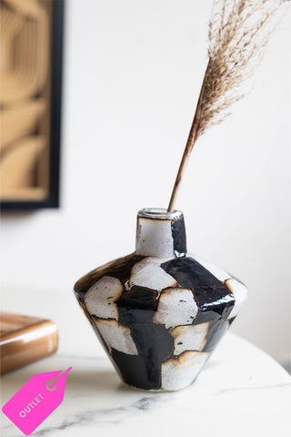 A beautiful crackled glass vase with a single stem on a coffee table.