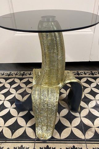 Side view of the black and gold banana side table. You can see the smoked glass.