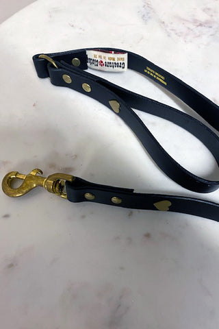 A beautiful black dog lead with gold hearts and studs up the length of the lead.