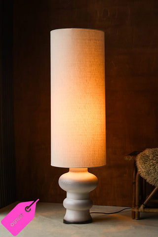 A lit glazed floor lamp.