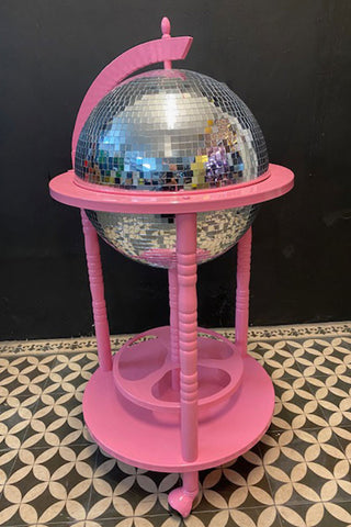 A closed disco ball drinks trolley with a bright pink frame.