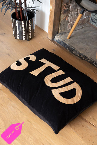 A black dog bed with the words 'stud' in bold lettering across the front of the quirky bed.