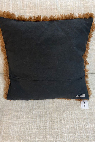 The black linen reverse of the fluffy cushion