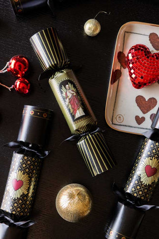 Red and black crackers flatlay with gold baubles, crackers and trays