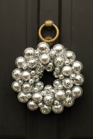 stunning silver wreath with disco balls and tinsel on a black front door.