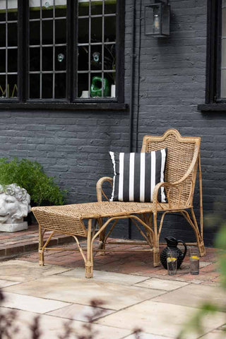 Lifestyle image of the Beautiful Cane Seated Sun Lounger on a patio